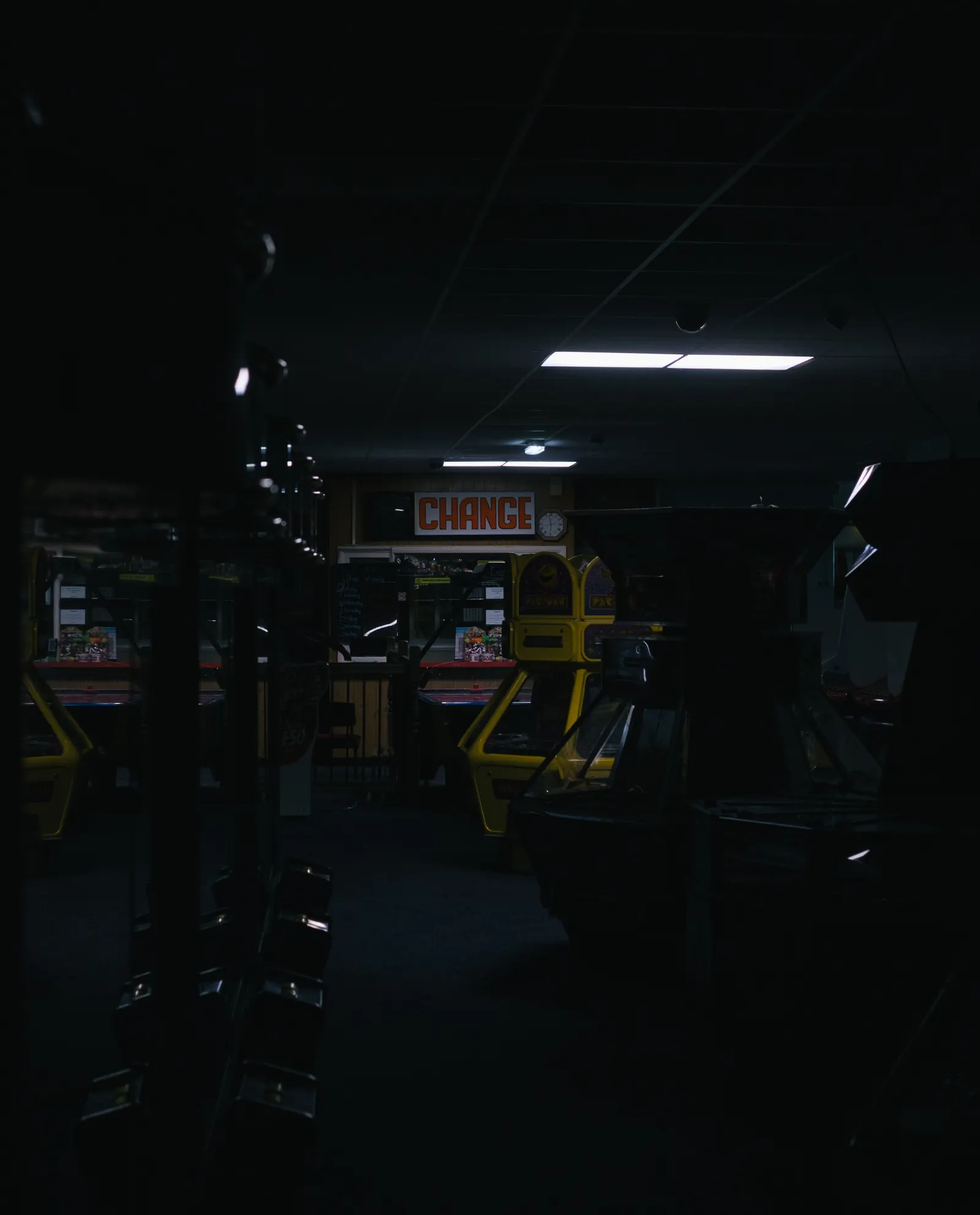 A dark, empty arcade with its cabinets switched off.