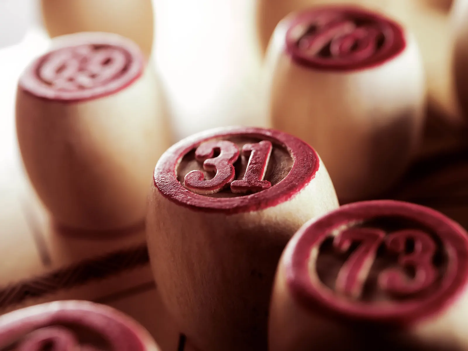 Wooden bingo pieces with red numbers.