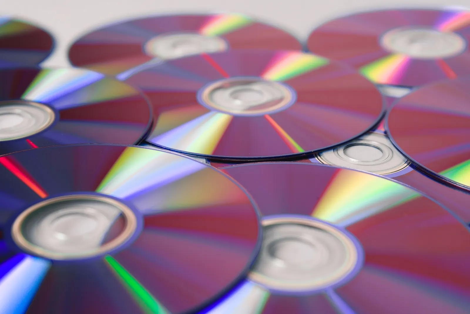 Overlapping compact discs catching rainbow reflections.