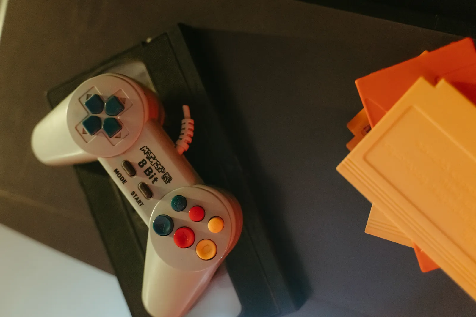 A retro gamepad beside game cartridges.