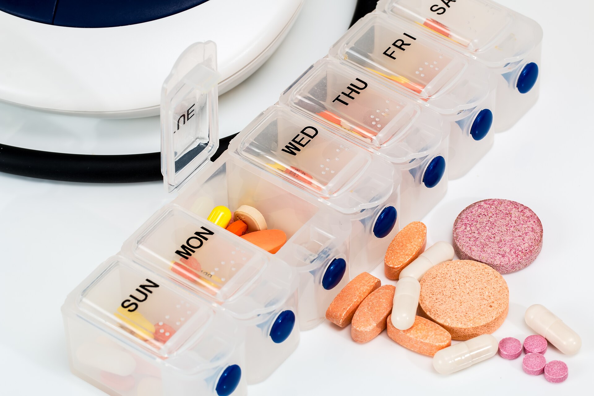 A weekly pill organizer with the Monday lid open.