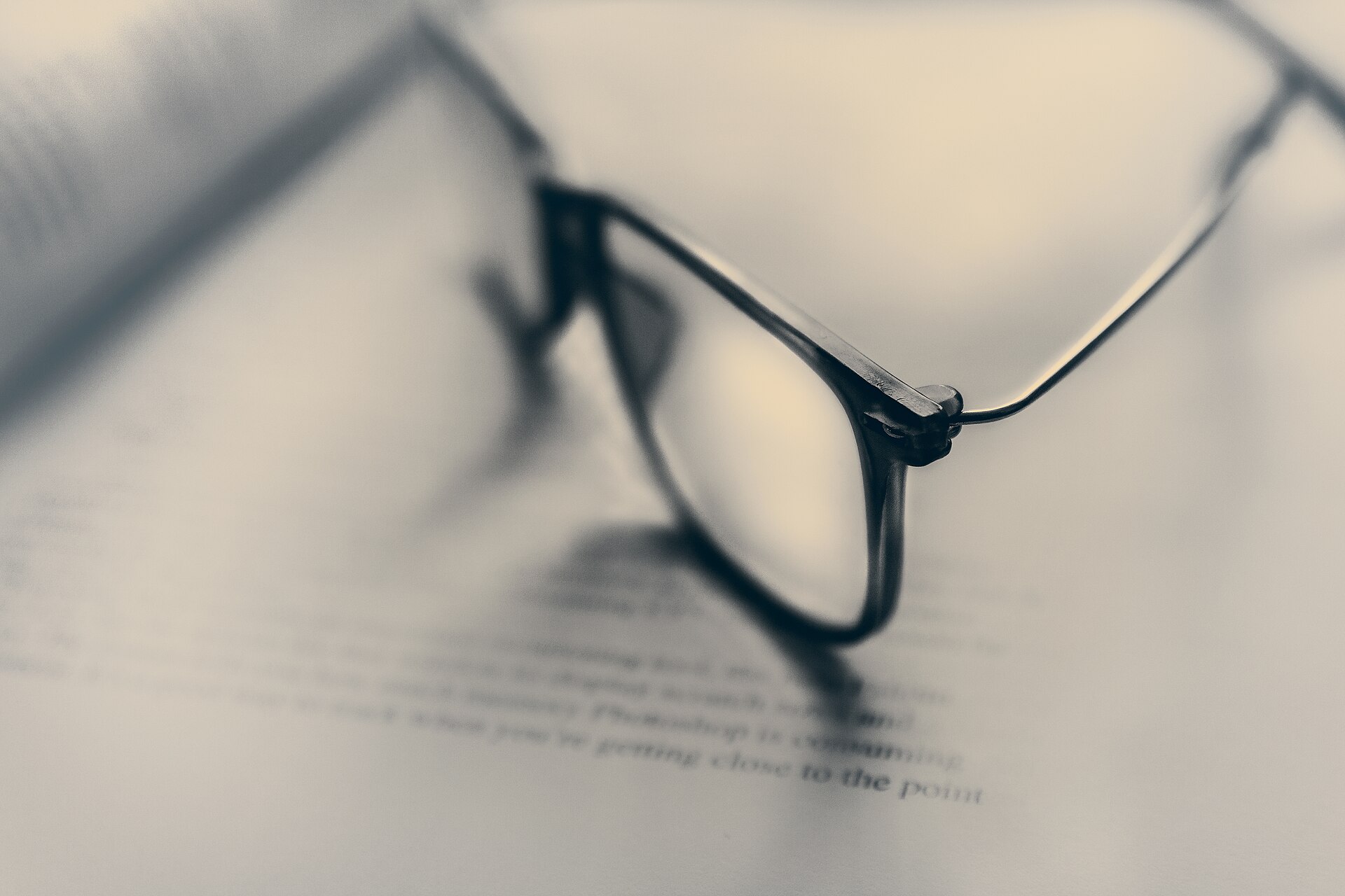 Reading glasses resting on an open book.