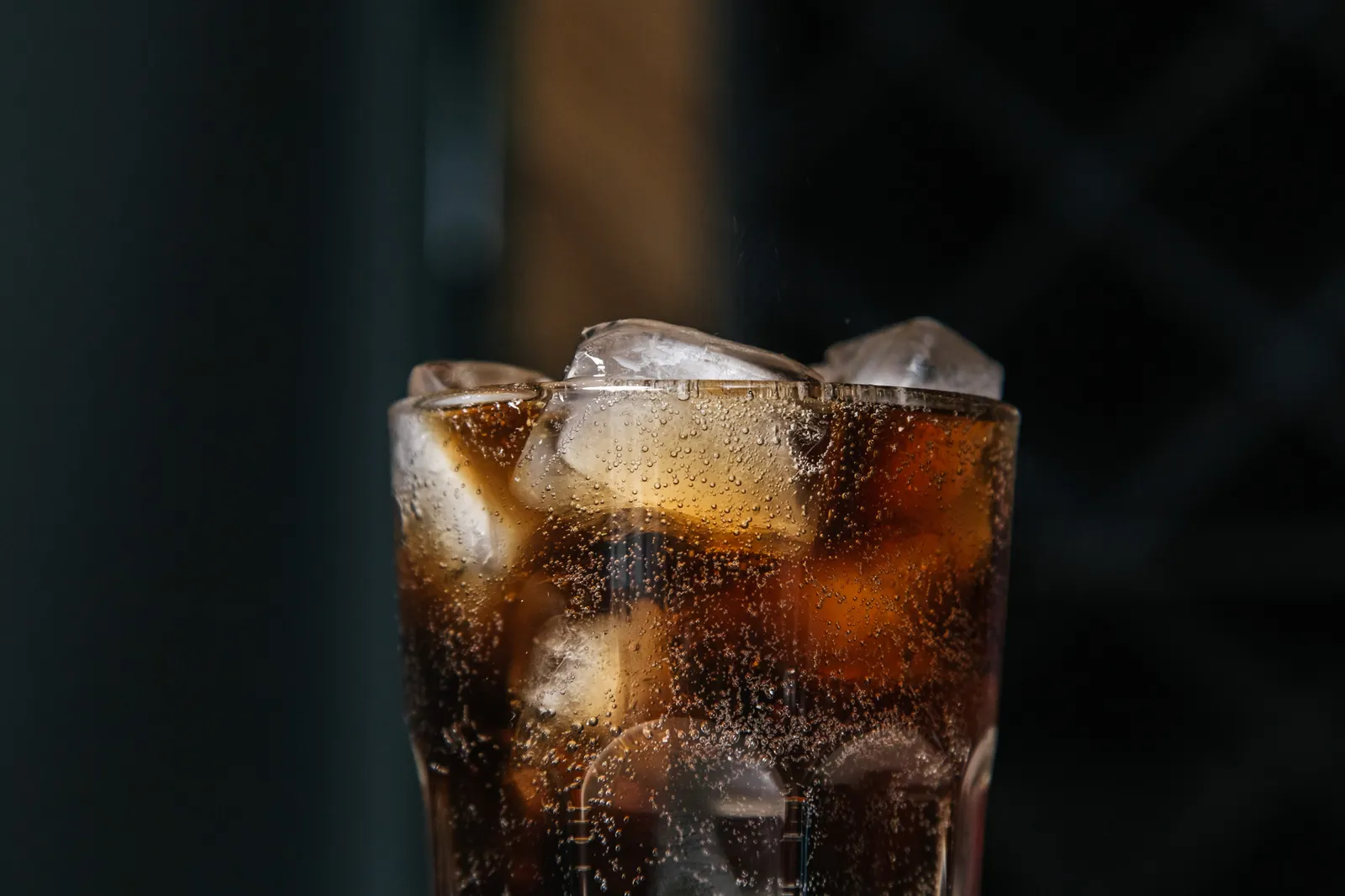 A glass of fizzy soda with ice.